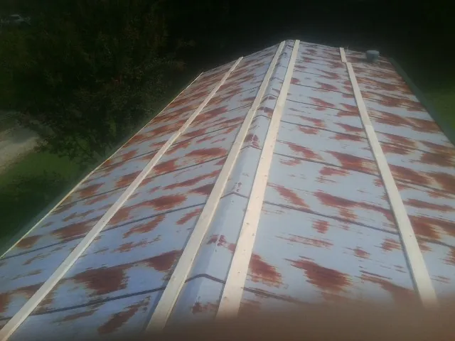 Rusted metal roof panels with new wood purlins before replacement — Storm Damage Roof Repair in Windsor by Roofing Brothers